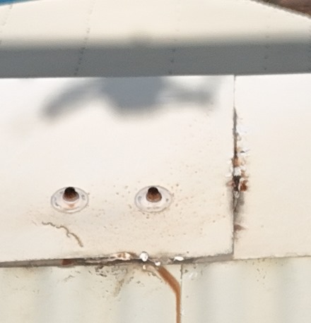 Faitage en tôle beige fortement corrodé, avec traces de rouille visibles, situé en climat tropical à La Réunion