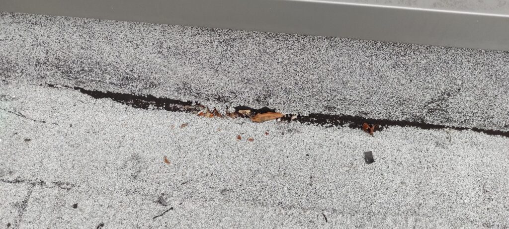 Flashing de relevé décollé sur une terrasse en étanchéité bitumineuse à La Réunion, montrant un problème d’étanchéité.