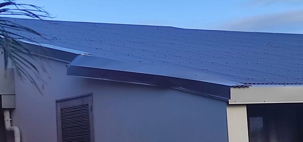 Rive de toiture en tôle partiellement arrachée après le passage du cyclone Belal, île de la Réunion.