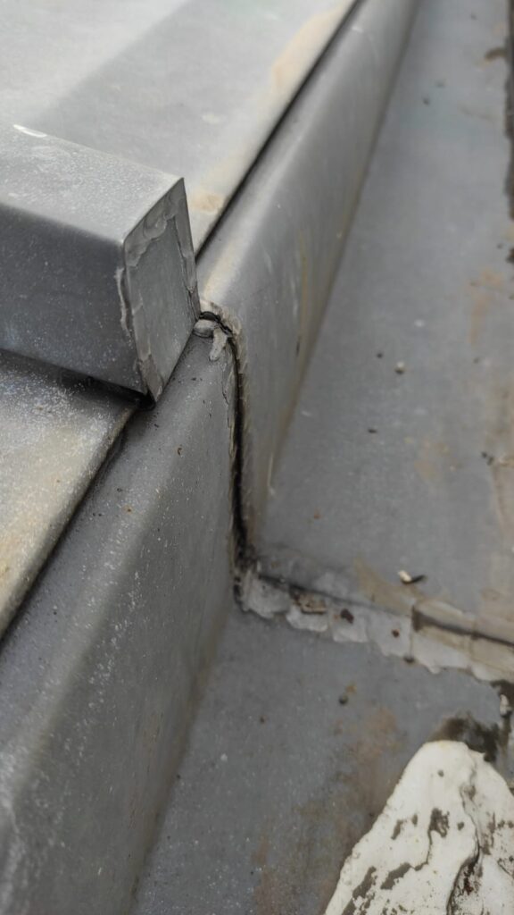 Soudure non conforme et manque de dilatation sur jonctions d’un chéneau en zinc cassé, île de la Réunion.